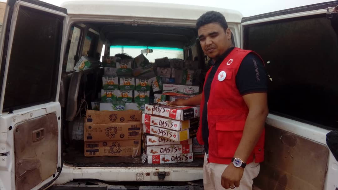 Voluntario de Cruz Roja descarga una furgoneta con comida para los escolares de los campos de refugiados saharauis en Tinduf (Argelia)