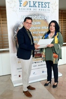 El director general del ICA, Manuel Cebrián y la directora de Folkfest, Alicia Baltasar, frente al cartel de la nueva edición del festival.