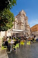Unos turistas sentados en una terraza junto a la Catedral de Murcia.