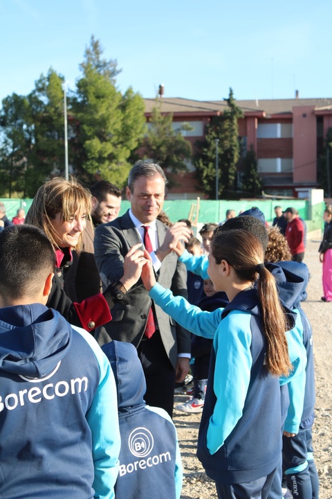 El consejero de Presidencia, Turismo, Cultura y Deportes, Marcos Ortuño, y la alcaldesa de Archena, Patricia Fernández, saludan a niños de la escuela deportiva que utilizarán el nuevo campo de fútbol.