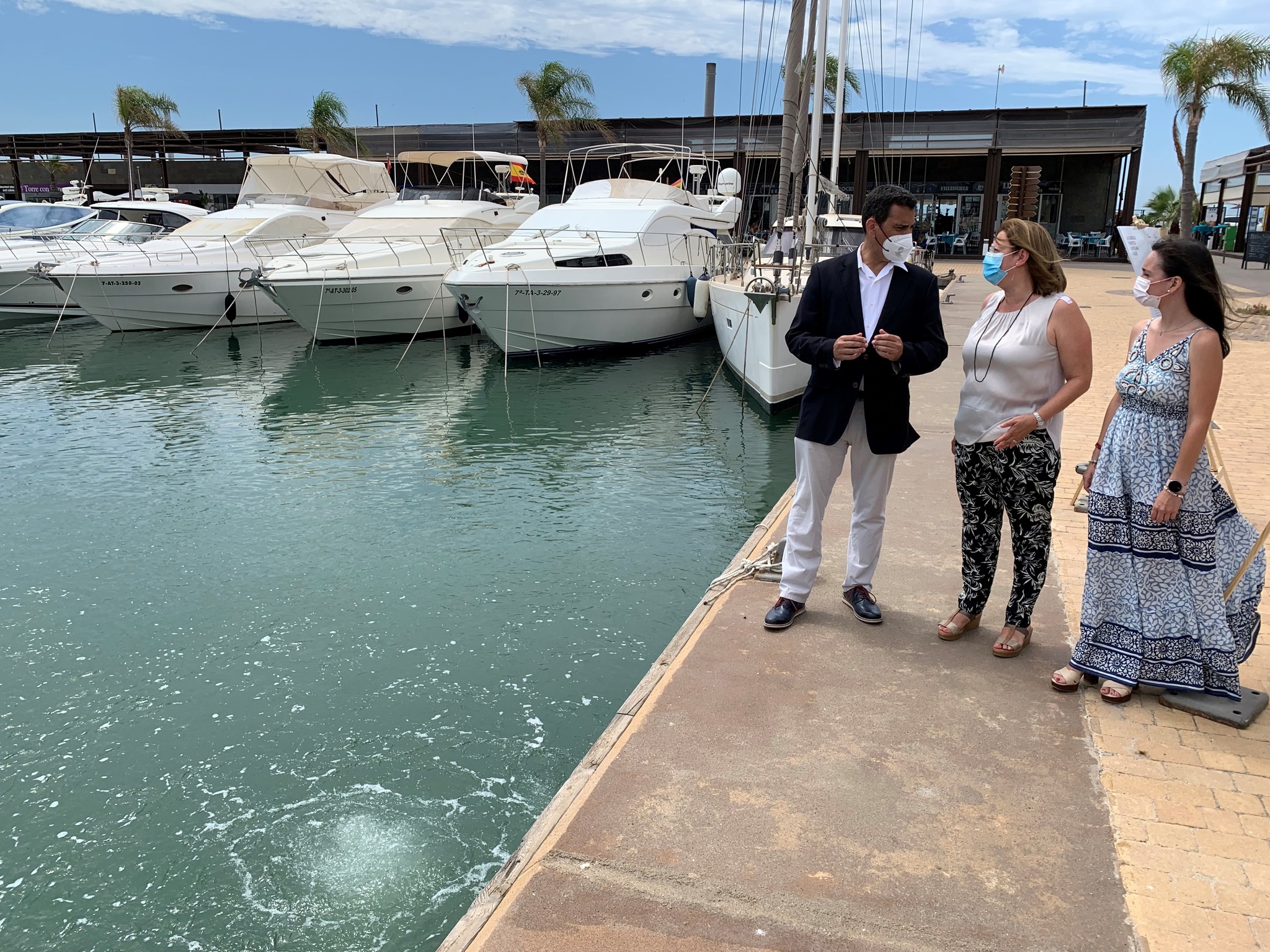 El consejero José Ramón Díez de Revenga, la alcaldesa Visitación Martínez, la directora Marina Munuera durante la demostración del sistema implantado en el puerto deportivo Marina de las Salinas que crea una cortina de microburbujas de aire que oxigena las aguas del reciento portuaria y evita posibles fugas de residuos fuera de la dársena