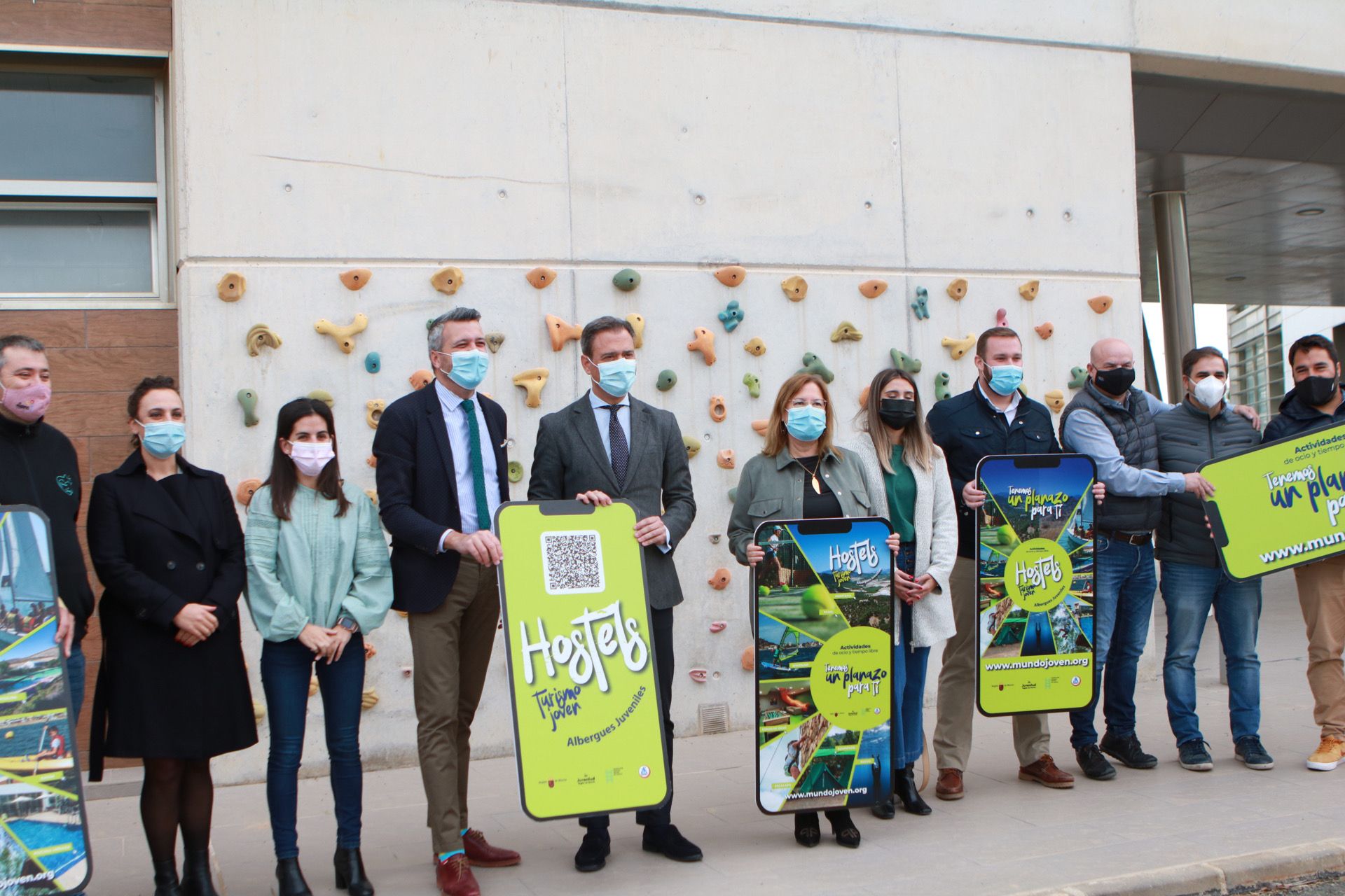 El consejero de Presidencia, Turismo y Deportes, la alcaldesa de San Pedro del Pinatar y el director general de Juventud, acompañados por representantes de los albergues juveniles, muestran la imagen gráfica de la campaña tras su presentación