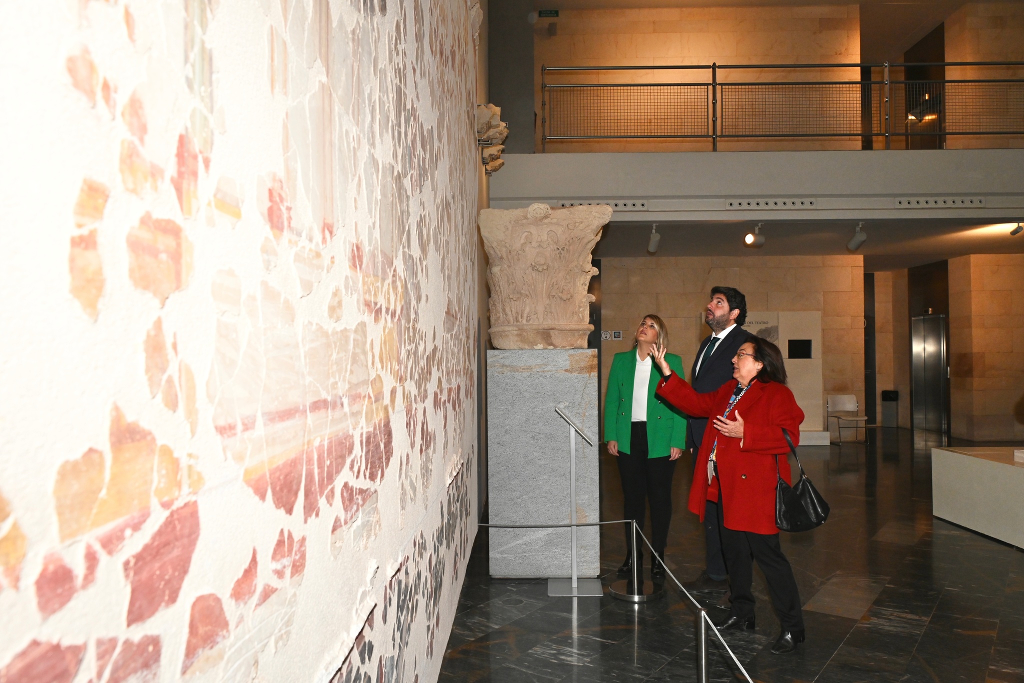 López Miras, la alcaldesa de Cartagena, Noelia Arroyo, y la directora del Teatro Romano de Cartagena, Elena Ruiz Valderas, visitan el mural con las piezas recuperadas del pórtico del Teatro Romano de Cartagena