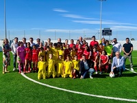 Autoridades y jóvenes jugadores en la inauguración del nuevo césped
