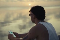 Fotograma del videoclip 'Tuchat' de Quevedo en el que el artista mira el atardecer en el Mar Menor