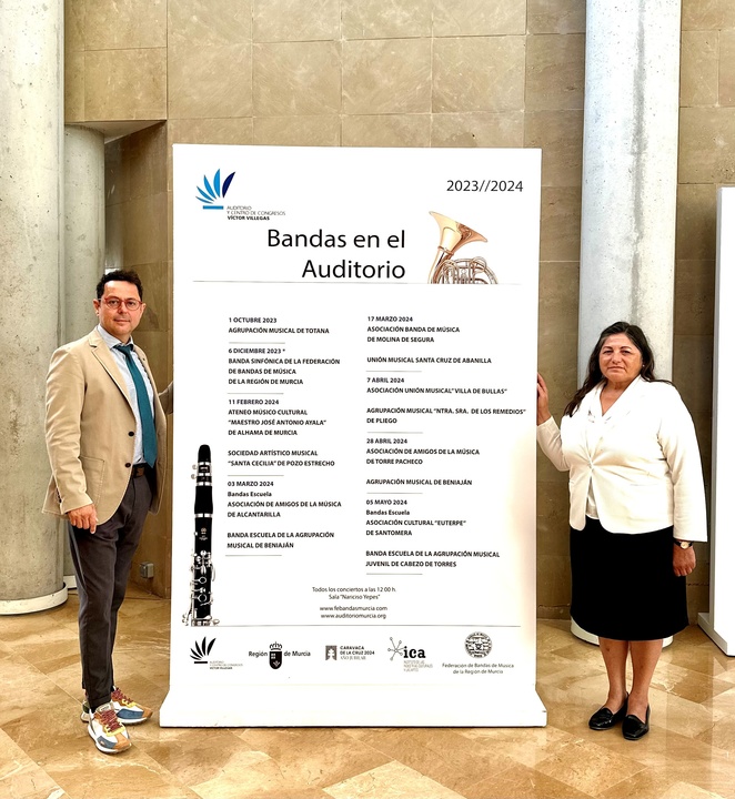 El director general del Instituto de las Industrias Culturales y las Artes, Manuel Cebrián, y la presidenta de la Federación de Bandas de Música de la Región de Murcia, Ginesa Zamora, junto al cartel del ciclo 'Bandas en el Auditorio'.