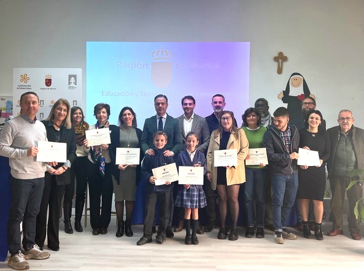 El consejero de Presidencia, Portavocía y Acción Exterior, Marcos Ortuño, y el director general de Acción Exterior y Cooperación, Juan José Almela, junto a dos alumnos y representantes de las ONGD que han recibido los diplomas como reconocimiento a su participación en este programa.