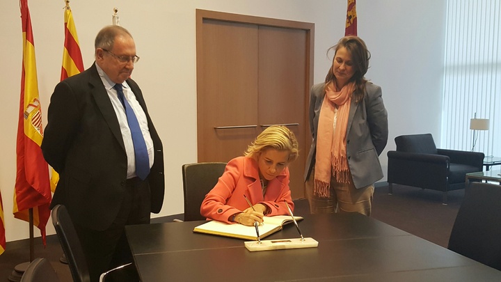 La consejera firma en el libro de honor de la feria acompañada por el presidente del consejo de administración de Fira Barcelona, Josep Lluis Bonet (izquierda), y la consejera de Cataluña, Meritxel Serreta
