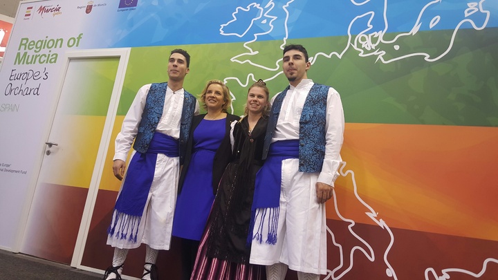 La consejera, con tres alumnos de la Escuela de Hostelería y Turismo de Murcia que han ofrecido miles de tapas típicas en el stand institucional de la Región de Murcia