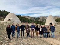 El consejero Antonio Luengo y representantes de instituciones y empresas vinculadas a la restauración, con los dos pozos de la nieve detrás.