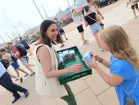 La consejera Sara Rubira entrega fruta de hueso de la Región de Murcia a una turista llegada en crucero a Cartagena.