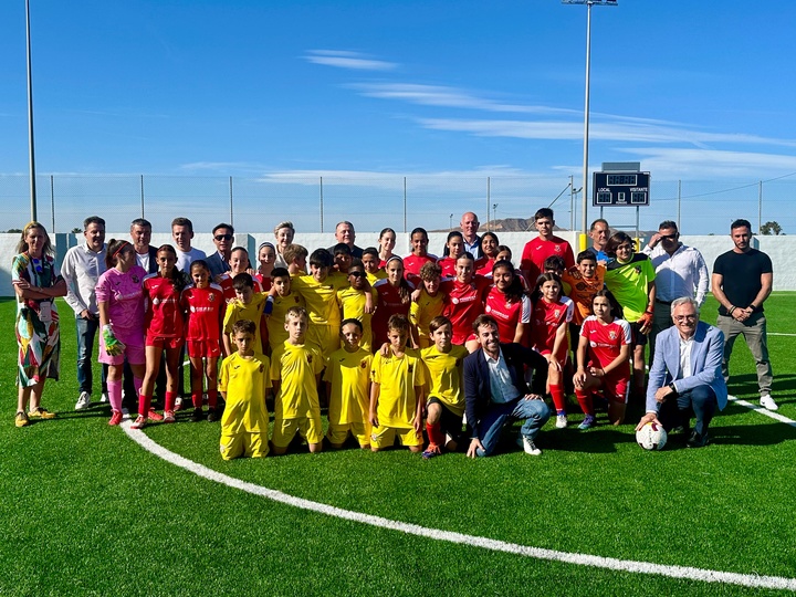 Autoridades y jóvenes jugadores en la inauguración del nuevo césped