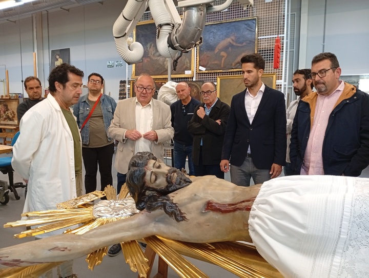 El director del Centro de Restauración, Javier Bernal, el alcalde de Cieza, Tomás Rubio, y miembros de la cofradía observan al Cristo del Consuelo