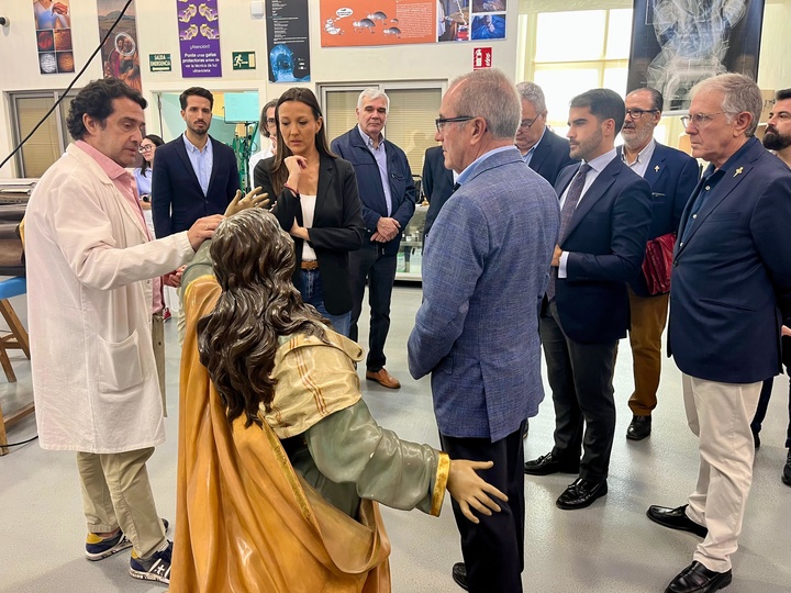 La consejera Carmen Conesa atiende a las explicaciones sobre la imagen de María Magdalena, del grupo del Calvario.